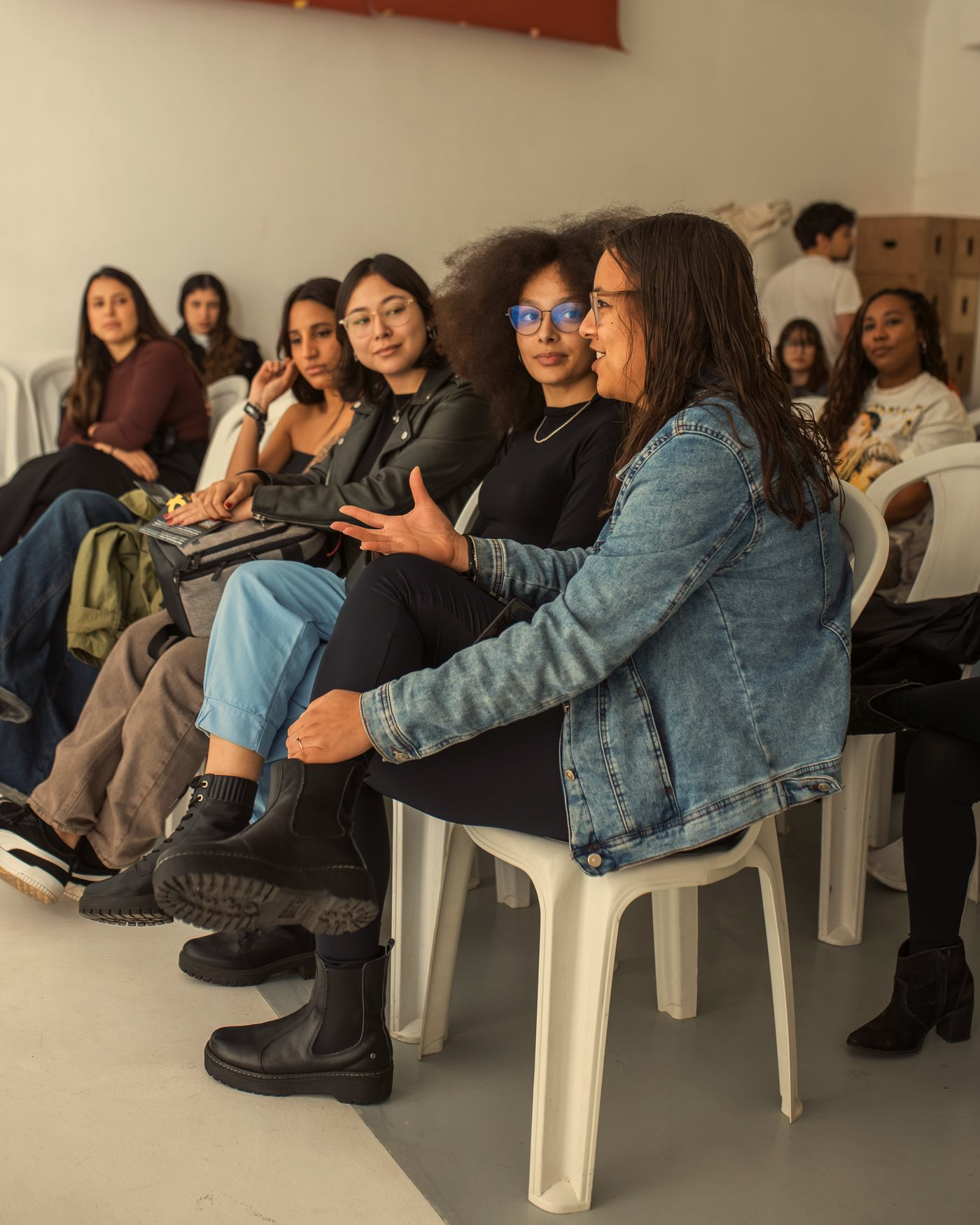 Grupo pequeno de pessoas em uma aula de marketing digital, conversando sentadas em roda